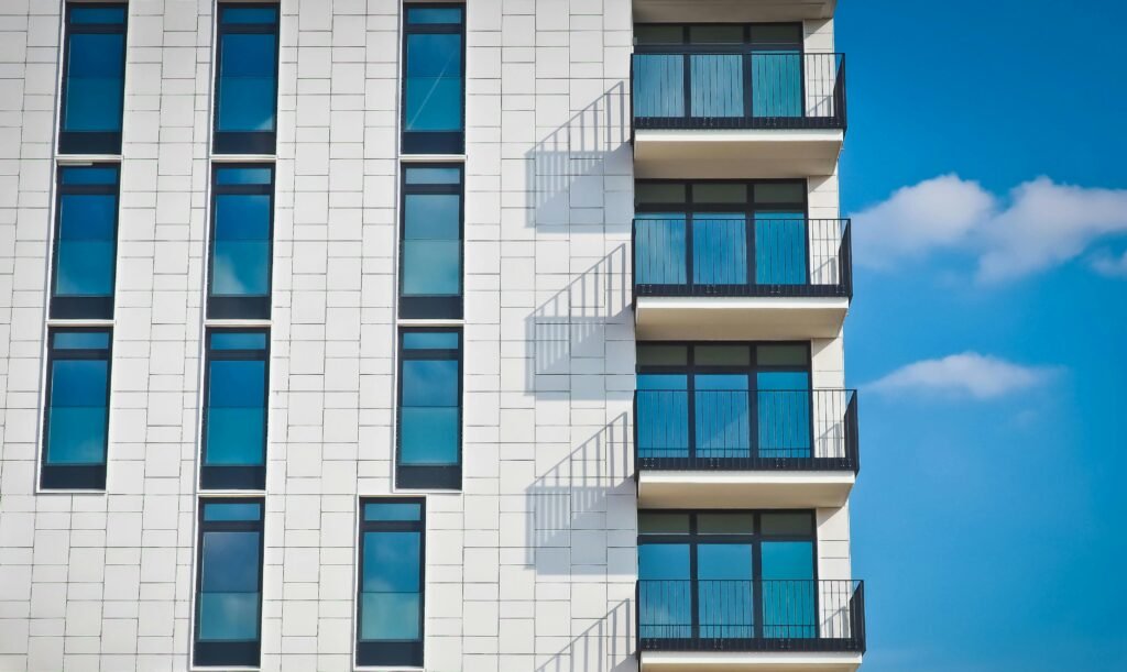 pexels photo 259950 259950 Contemporary urban apartment building with framed glass windows against clear blue sky.